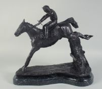 A GOOD BRONZE HORSE AND JOCKEY over the sticks, on a shaped marble base. 13ins long.