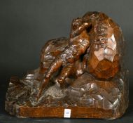 A Continental wood carving of a nude male figure moving a rock bearing figureheads, circa 1900,