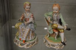 A pair of Dresden porcelain seated figures of a man and women.