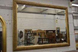 A modern rectangular gilt framed mirror.