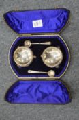 A cased pair of circular silver salts with spoons.