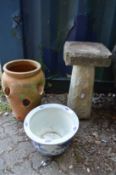 A bird bath and two planters.