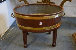 A George III mahogany and brass bound oval wine cooler or jardiniere on stand.