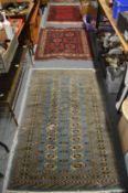 A blue ground bokara style rug, 160cm x 97cm together with two small red ground Persian rugs,