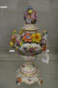 A Dresden floral encrusted twin handled pedestal urn and cover.