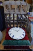 An enamel wall clock, two cushions and two wine racks.