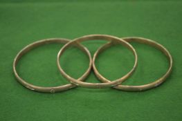 Three silver bangles.