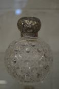 A hobnail cut glass scent bottle with hinged embossed silver lid.