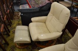 An Ekornes Stressless cream leather swivel reclining armchair with matching foot stool.