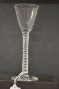 An 18th century English wine glass with inverted bowl and air twist stem.