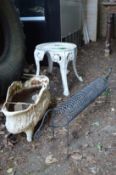 A wrought iron sausage dog, cast iron planter and an aluminium stool.