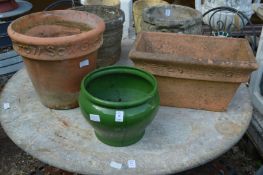 A green glazed planter and two terracotta plant pots.