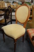 A set of four beech framed and upholstered oval back dining chairs.