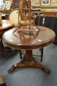 A small circular mahogany tilt-top table.