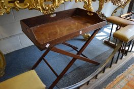 A mahogany butlers tray on folding stand.