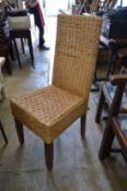 A set of eight wicker dining chairs.