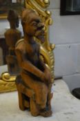 A tribal carved wood seated male figure.