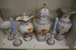 A garniture of floral decorated porcelain to include vases and candlesticks and a jug.