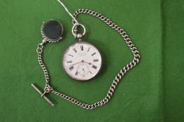 A silver pocket watch with silver chain and fob seal.