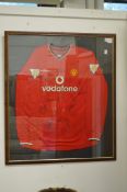 A Manchester United football shirt, signed and framed and glazed.