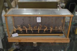 A group of miniature bamboo musicians in a glazed display case.