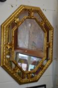 A decorative gilt framed octagonal shaped wall mirror.