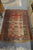 A small Persian rug, worn, 140cm x 97cm.