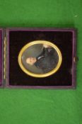 A portrait miniature of a Gentleman seated at a desk in a leather case.
