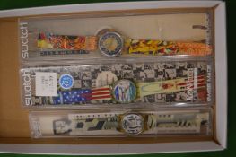Three Swatch wrist watches.