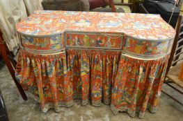 A decoratively upholstered dressing table.