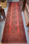 A Persian style runner, red ground with seven large motifs, 290cm x 80cm.