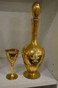 A gilt decorated glass liqueur bottle and glass.