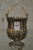A hammered white metal pedestal swing handle basket.