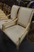 A pair of French style cream painted armchairs.