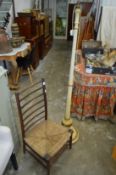 A rush seated chair and a painted standard lamp.