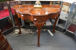 A mahogany side table of shaped outline on cabriole legs.