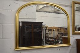A modern gilt framed over-mantle mirror.
