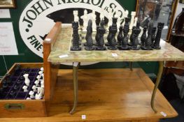 An oynx chess table, a chess set and spare chess pieces.