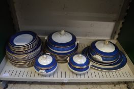 A quantity of blue and gilt decorated dinner ware.