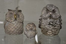 A set of three silver overlaid models of owls.