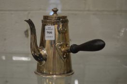 A silver coffee pot with turned wood handle.