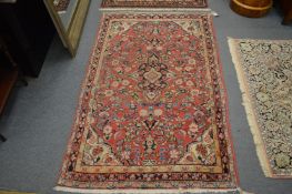 A Persian rug, pink ground with floral decoration, 168cm x 103cm.