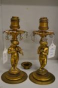 A pair of ormolu cherub form candlesticks converted to electricity.