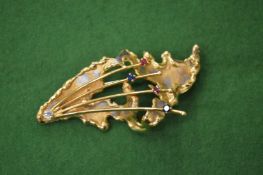 An 18ct gold and gem set brooch of naturalistic form.