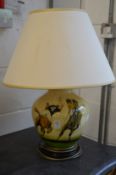 A pottery table lamp painted with a polo playing scene.