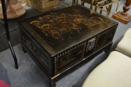 A Chinese lacquer storage box on stand with glass top (for use as a coffee table).