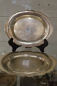 A pair of silver dishes with shaped rims.