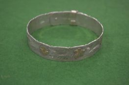 An engraved silver bangle.