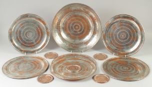 A COLLECTION OF TINNED COPPER DISHES AND COASTERS, large dish 36cm diameter, six dishes 29.5cm