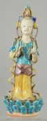 A CHINESE FAHUA-TYPE FIGURE OF GUANYIN, stood upon a lotus formed base, 22.5cm high.